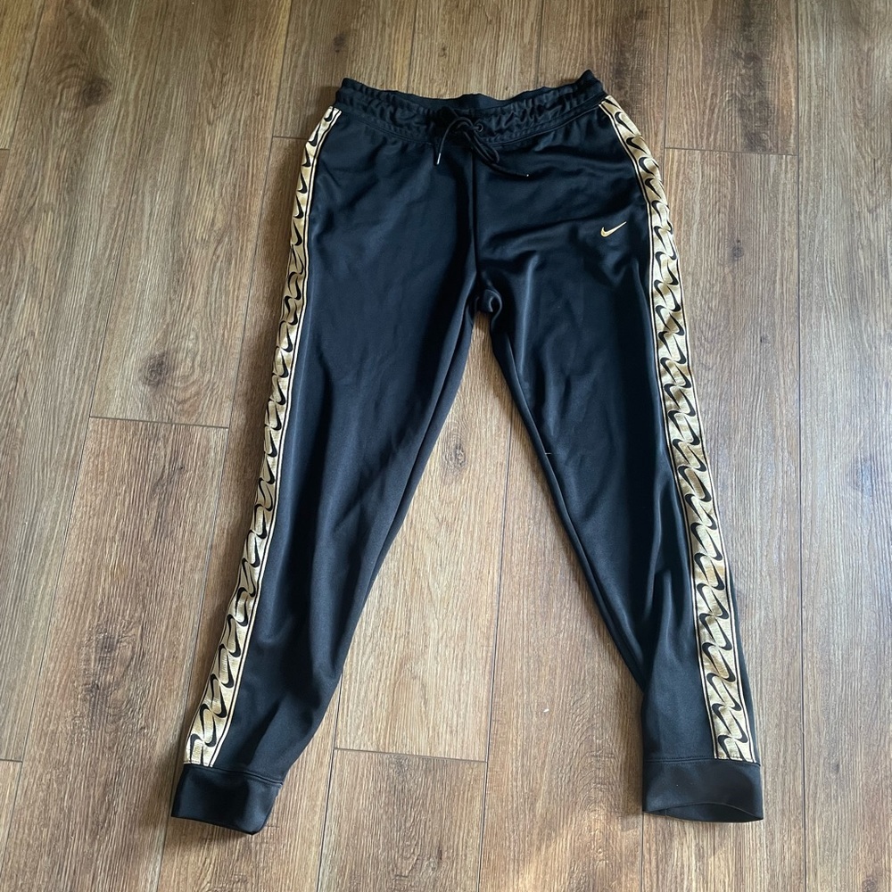 Black Nike joggers with gold down the side